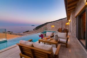 a patio with a table and chairs next to a pool at Water Edge 3 in Kaş