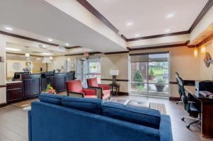 sala de estar con sofá azul y sillas en Comfort Inn & Suites Hillsville I-77 en Hillsville
