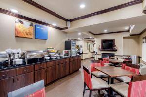 a restaurant with tables and chairs and a kitchen at Comfort Inn & Suites Hillsville I-77 in Hillsville