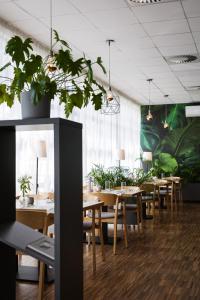 un comedor con mesas de madera y macetas en Hotel Lechicka, en Poznan