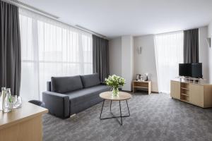 a living room with a couch and a table at Hotel Lechicka in Poznań