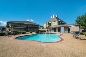 ein Haus mit einem Pool vor einem Haus in der Unterkunft Quality Inn & Suites - Garland in Garland