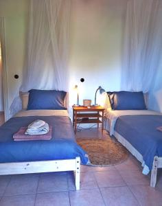 a bedroom with two beds and a table with a lamp at Lulani Hideaway by Air Vitesse in Áyios Pandeleḯmon