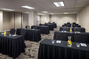 einen Konferenzraum mit schwarzen Tischen und Stühlen in der Unterkunft The Elms Hotel & Spa, a Destination by Hyatt Hotel in Excelsior Springs