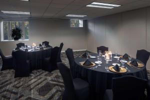 uma sala de conferências com duas mesas e cadeiras e um conjunto de mesa para o jantar em The Elms Hotel & Spa, a Destination by Hyatt Hotel em Excelsior Springs