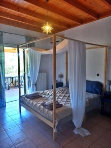 a bedroom with a bed with a canopy at Lulani Hideaway by Air Vitesse in Áyios Pandeleḯmon