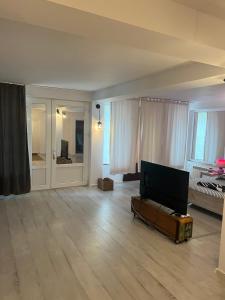 an empty living room with a couch and a television at Vila Alga in Sulina