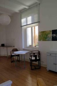 ヴッパータールにあるGästeappartement im Atelierhausのテーブルと椅子、窓が備わる客室です。