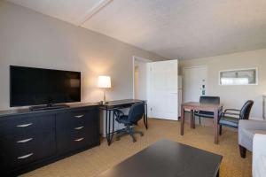 a living room with a flat screen tv and a desk at Quality Inn & Suites in Auburn