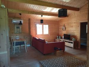 a living room with a red couch and a table at Casa do Vale de Gondra in Castelo de Paiva