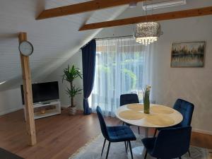 a living room with a table and chairs and a tv at Apartments MILENA in Druskininkai