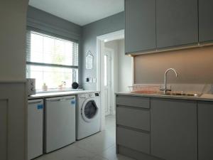 a kitchen with a washing machine and a sink at Rose Haven private home between Dungannon & Omagh in Dungannon