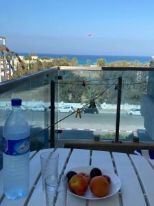 un plato de fruta en una mesa con una botella de agua en Lovely 1-bedroom rental unit with sea view, en Mahdia