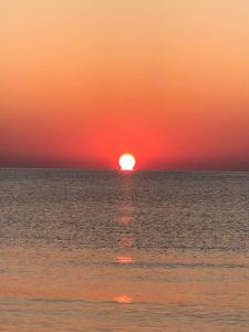 a sunset over the ocean with the sun in the horizon at Lovely 1-bedroom rental unit with sea view in Mahdia