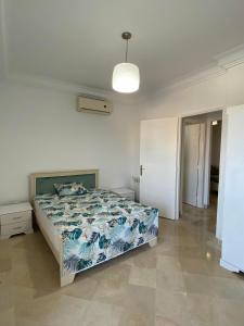 a bedroom with a bed with a blue and white comforter at Lovely 1-bedroom rental unit with sea view in Mahdia
