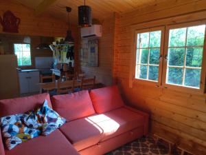 a living room with a red couch in a cabin at Casa do Vale de Gondra in Castelo de Paiva