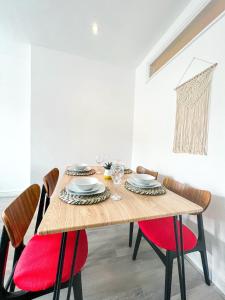 a dining room with a wooden table and red chairs at The County Staycation in Liverpool