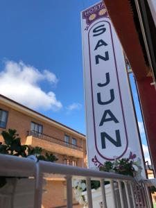 una señal para un hotel frente a un edificio en Hostal San Juan, en Sahagún