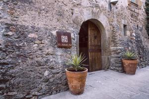 um edifício de pedra com dois vasos de plantas na frente de uma porta em Hotel Monells Summum em Monells