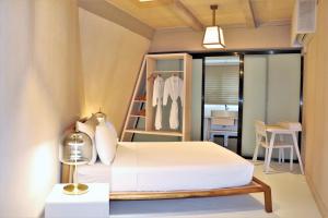 a bedroom with a white bed and a closet at Asmara Lifestyle Hotel in Cebu City