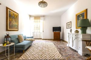 a living room with a couch and a tv at Hostly - Il Casale dei Ninì in San Giuliano Terme