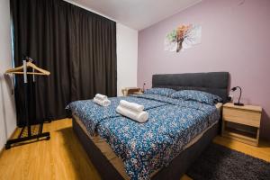 a bedroom with a bed with towels on it at Venite apartments in Velika