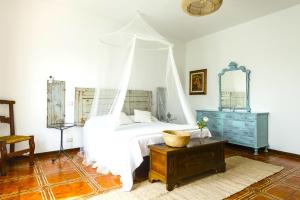 a bedroom with a white bed with a canopy at Hostly - Il Casale dei Ninì in San Giuliano Terme