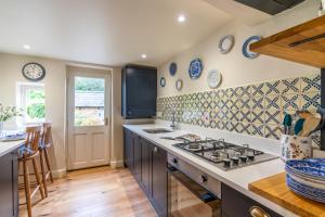 a kitchen with blue and white tiles on the wall at Vine Cottage in Charlbury