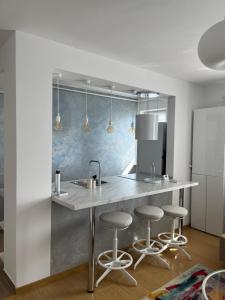 a kitchen with a counter and bar stools at Alma apartments in Suceava