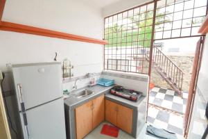 a small kitchen with a sink and a refrigerator at Villa 969 with Private Pool in Port Dickson