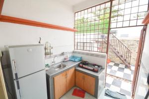 a small kitchen with a sink and a refrigerator at Homestay PD Villa 969 with Private Pool in Port Dickson