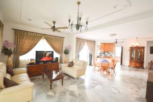 a living room with a couch and a tv at Homestay PD Villa 969 with Private Pool in Port Dickson
