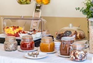 una mesa con tarros de mermelada y un buffet de comida en Jacobs Inn Barcelona, en Barcelona