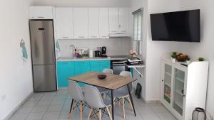 a kitchen with a wooden table and blue cabinets at Kalybeach Studio in Kalives Poligirou