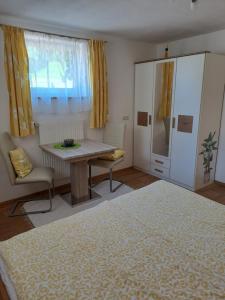 a bedroom with a bed and a table and a chair at Kathis Appartement in Flachau