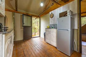 a kitchen with a white refrigerator and a wooden floor at Tranquil Nest in Hazyview