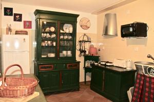 a kitchen with a green hutch and a refrigerator at Casa do Balcão in Alcains +20 photos