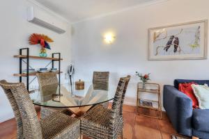 a dining room with a glass table and chairs at Parap Markets Condo 2BR 2BA (ens) in Paraparap