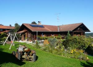 a tractor sitting in the grass in front of a house at Für Ihren Urlaub 2024 Fremdenzimmer-Appartement Eurasburg im Loisachtal - Tölzer Land in Eurasburg