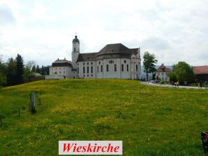 un gran edificio en lo alto de un campo verde en Für Ihren Urlaub 2024 Fremdenzimmer-Appartement Eurasburg im Loisachtal - Tölzer Land, en Eurasburg