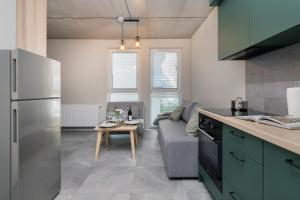 uma cozinha e sala de estar com um sofá e uma mesa em Modern Studio in Gdańsk, Rybaki Górne by Renters em Gdansk