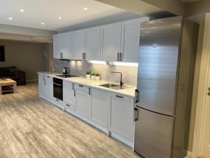 a kitchen with white cabinets and a stainless steel refrigerator at Notodden Sentrum Apartment NO 9 in Notodden
