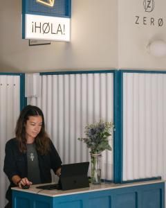 a woman sitting at a desk with a laptop computer at Jacobs Inn Barcelona in Barcelona