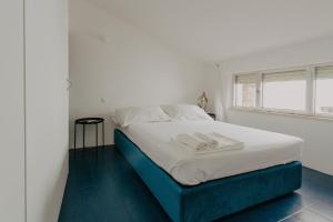 a bedroom with a bed with white sheets and a window at da COSO in Ripatransone