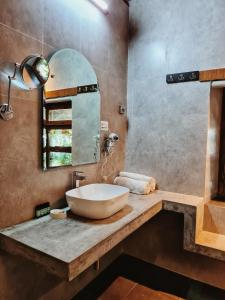 W łazience znajduje się umywalka i lustro. w obiekcie Deodar Homestay w mieście Almora