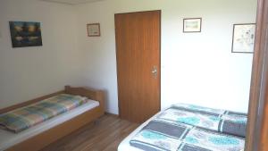 1 dormitorio con 1 cama y puerta de madera en B4 Schwarzwald-Fewo an der Alb, en Menzenschwand