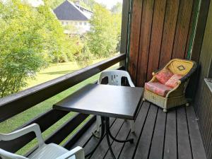 una mesa y sillas en el porche de una casa en B4 Schwarzwald-Fewo an der Alb, en Menzenschwand