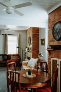 un salon avec une table et une horloge sur un mur de briques dans l'établissement Cottage on Gray - Wangaratta, à Wangaratta