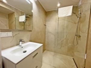 a bathroom with a sink and a shower at Timber Apartments by Baltic Home in Świnoujście
