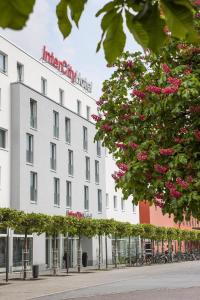 un edificio blanco con un letrero de farmacia. en IntercityHotel Ingolstadt, en Ingolstadt